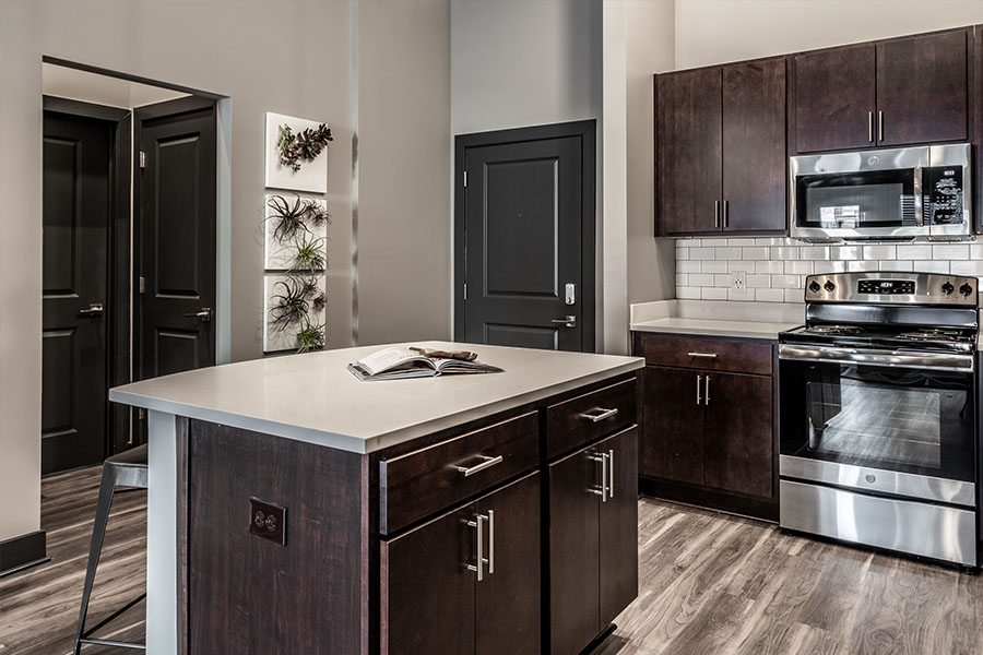 Upscale apartment kitchen with island and dark wood cabinetry