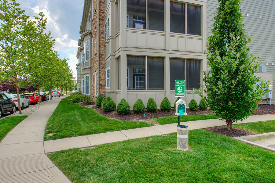 Dog waste station in grassy area outside of apartment building